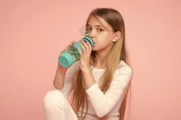 Διψασμένος παιδί πίνετε νερό για την υγεία σε ροζ φόντο. Παιδιά κρατήστε μπουκάλι νερό. Κοριτσάκι με πλαστικό μπουκάλι. Δίψα και αφυδάτωση. Παιδική ηλικία δράση και την ενέργεια, punchy παστέλ τάση — Φωτογραφία Αρχείου