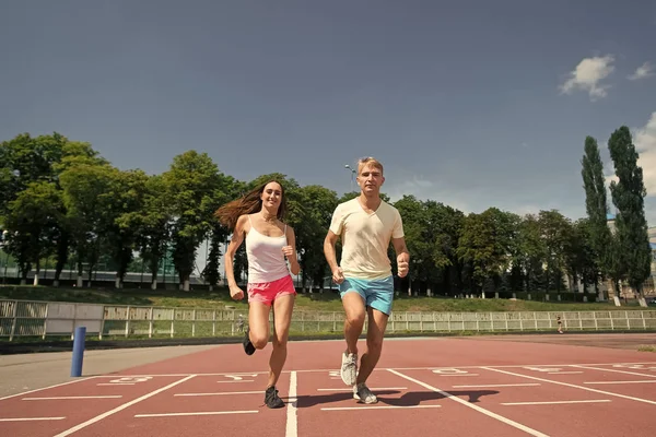 Couple running on arena track — Stock Photo, Image