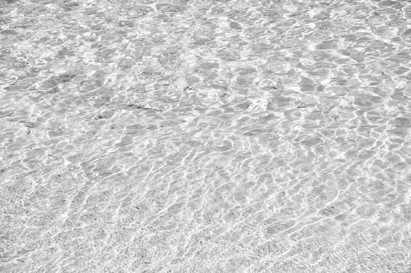 Vågigt vatten bakgrund på sand — Stockfoto