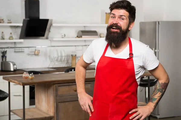 Chef seguro y experimentado. Hipster en la cocina. Hombre maduro. Cocinero barbudo. Restaurante o cafetería cocinero. Hombre barbudo con delantal rojo. Cocinero hombre. cocina del restaurante. Hombre barbudo feliz en delantal —  Fotos de Stock