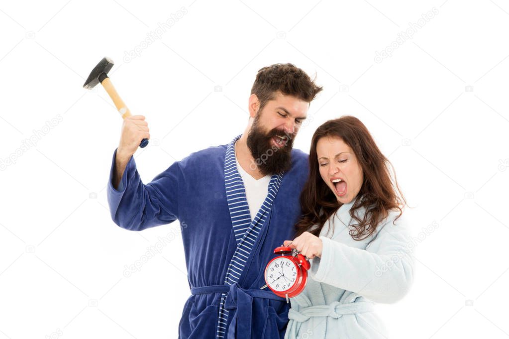 Too much noise. Couple oversleep awakening hold alarm clock. Lack of sleep. Too early awakening. Oversleep, not getting enough sleep concept. Frustrated tired couple oversleep. angry man and woman