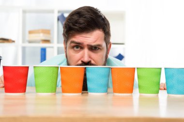 Difficult choice. decision-making. serious and sad man with colorful coffee cups. Many cups of coffee. hard choice to make. i need more coffee. low energy. Taking decisions. mature hipster man clipart