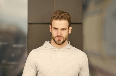 Casual tarzda. Ciddi yüz açık sakallı adam. Temiz hava üzerinde gri sweatshirt içinde maço. Bir dakika mola. Sporty yakışıklı