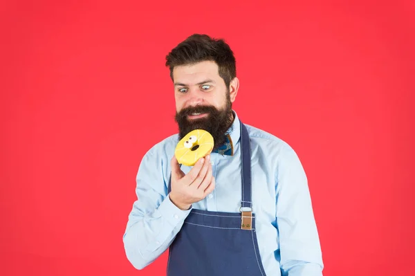 Chef au café. Calorie alimentaire. Homme barbu dans un tablier. Nourriture aux beignets. Régime alimentaire et des aliments sains. boulanger tenir beignet. Un drôle de hipster. De la bonne nourriture. Calorie. Ressens la faim. Collation pour la productivité des entreprises — Photo