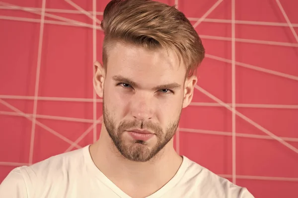 Homme avec soies sur le visage concentré strict, fond rose. Concept de masculinité. Homme à la barbe ou mec non rasé semble beau et bien entretenu. Guy barbu et attrayant avec la coiffure — Photo