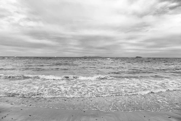 Bulutlu plaj dalgalı su ile — Stok fotoğraf