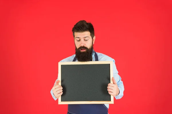 Désolé que nous soyons fermés. Barman Hipster montrer espace de copie tableau noir. Personnel du restaurant Hipster. Hipster vous informe. Homme barbu barman ou cuisinier dans tablier tenir tableau blanc. Concept de liste de prix — Photo