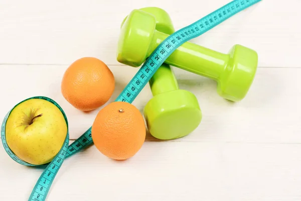 Weight dumbbells with measuring tape, apple, orange, diet concept — Stock Photo, Image