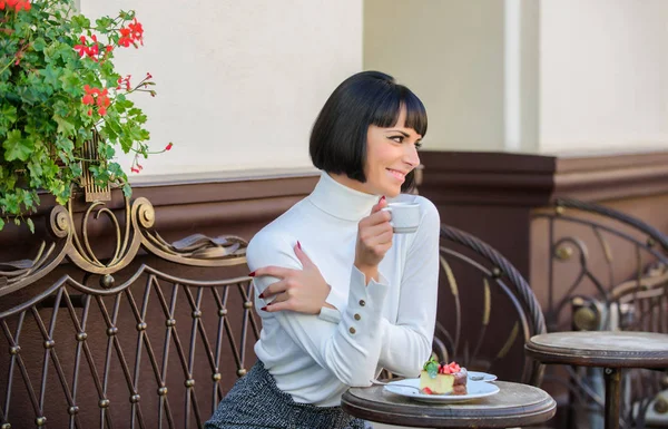 Delicious gourmet cake. Girl relax cafe with cake dessert. Gourmet concept. Woman attractive elegant brunette eat gourmet cake cafe terrace background. Pleasant time and relaxation. She loves sweets