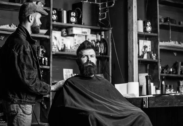Hipster klient dostał nową fryzurę. Fryzjer z maszynka do strzyżenia włosów patrząc w lustro, barbershop tła. Koncepcja fryzury. Kontrola wyników, podczas gdy klient siedzi w fotelu profesjonalny master. Fryzjer fryzura zrobione — Zdjęcie stockowe