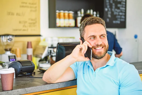 Coffee break concept. Lets meet in cafe. Man mobile conversation cafe barista background. Drink coffee while waiting. Coffee take away option for busy people. Man with smartphone order coffee