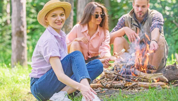 Spend great time on weekend. Roasting marshmallows popular group activity around bonfire. Youth at picnic roasting marshmallows. Company friends prepare roasted marshmallows snack nature background