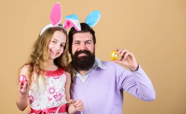 Naděje a znovuzrození. Šťastný otec a dítě s barevné velikonoční vajíčka. Šťastná rodina. Rodina slaví Velikonoce. Rodina otce a dcery úsměv v Velikonoční zajíček uši. Rodina na každoroční velikonoční vajíčka — Stock fotografie