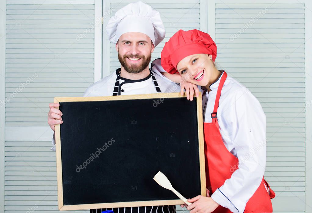 Mastering cooking skills. Couple of man and woman holding empty blackboard in cooking school. Master cook and prep cook giving cooking class. Chef and cook helper teaching master class, copy space