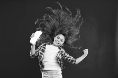 Uzun kıvırcık saçlı küçük kız. Küçük kız çocuk kırmızı zemin üzerine. Çocukluk. Kuaför salonu ve güzellik. sağlıklı saçlar için şampuan. mutluluk ve sevinç. mükemmel erkek. ürün sunumu