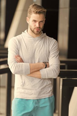 Spor onun yaşam tarzı. Adam sakallı ve çekici görünümü ile ilgili umurunda değil. Kıl ciddi yüz egzersiz kentsel arka plana hazır olan adam. Adam sakal tutmak vücut iyi durumda sağlıklı yaşam tarzı