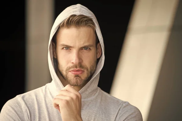 Logro futuro centrado. Chico barbudo ropa casual atractiva con capucha. Hombre con la cara concentrada cerda fondo urbano desenfocado. El hombre sin afeitar se ve guapo con capucha. Concentrado en el objetivo — Foto de Stock