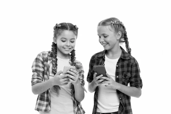 Chicas lindos niños pequeños sonriendo a la pantalla del teléfono. Les gusta navegar por internet en las redes sociales. Problema de la generación joven. Teléfono móvil y adicción a Internet u obsesión. Dependencia del teléfono móvil — Foto de Stock