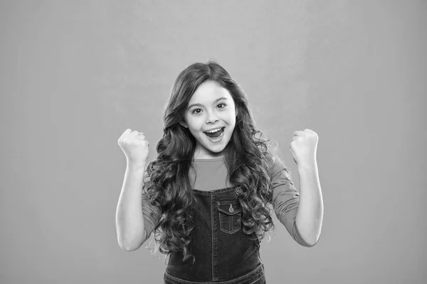 El niño alegre celebra la victoria. Niña lindo niño largo pelo rizado feliz sonriendo. Psicología y desarrollo infantil. Feliz ganador. Celebra la victoria o el logro. Un chico feliz y exitoso. Lograr el éxito — Foto de Stock