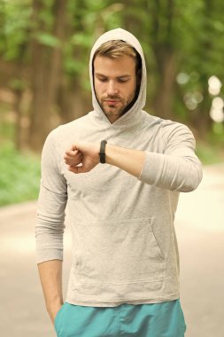 Onay zaman onun en iyi puanı. Adam atlet meşgul yüz fitness izci doğa arka plan kontrol edin. Kıl ile sporcu fitness izci veya pedometre görünüyor. Sporcu pedometre gadget ile eğitim