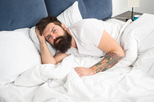 Man bearded hipster having problems with sleep. Guy lying in bed try to relax and fall asleep. Relaxation techniques. Violations of sleep and wakefulness. Need some rest. Sleep disorders concept