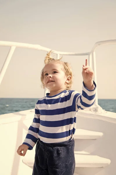 Conceito de rapaz. Marinheiro. Rapaz viaja no navio no mar. Rapaz, mantém o dedo apontador levantado. Olha para ali. — Fotografia de Stock