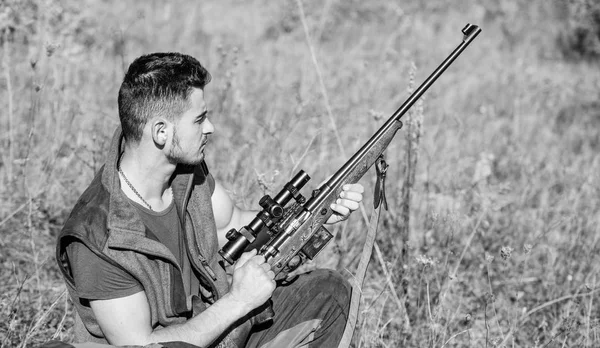 Jakt hobby och fritid. Mannen laddning jaktgevär. Jakt utrustning koncept. Jägare med gevär letar djuret. Hunter khaki kläder redo att jaga natur bakgrund. Jakt skytte trophy — Stockfoto