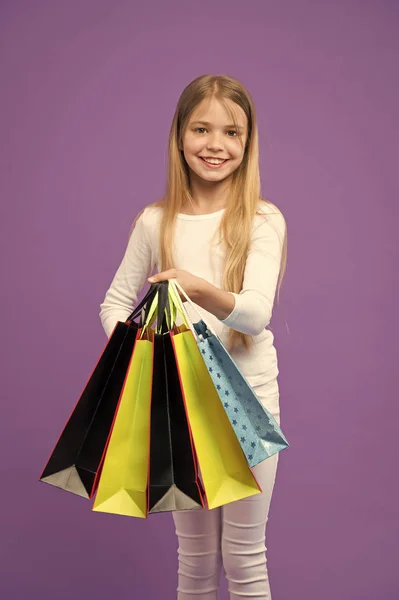 Menina com cabelo comprido gosta de fazer compras. Menina no rosto sorridente carrega cachos de sacos de compras, isolado no fundo branco. A menina gosta de comprar roupas da moda no shopping center. Conceito de compras — Fotografia de Stock