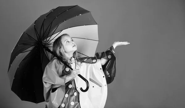 Disfrute del clima lluvioso con prendas adecuadas. Accesorios impermeables hacen que el día lluvioso alegre y agradable. Niña feliz celebrar paraguas colorido desgaste capa impermeable. Accesorios impermeables para niños —  Fotos de Stock