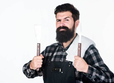 En iyi Barbekü tencere. Barbekü araçları elinde tutan sakallı adam. Spatula ve barbekü çatalı kullanarak yemek ızgara. Mutlu hipster Barbekü gıda hazırlama için paslanmaz çelik araçları holding