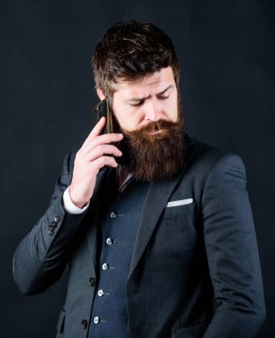 Yeni bir iş günü. Sakallı adam ile smartphone. Erkek resmi moda. Bıyıklı acımasız beyaz hippi. Takım elbiseli bir iş adamı. iş iletişimi. Olgun hipster sakallı telefonla konuşabilir