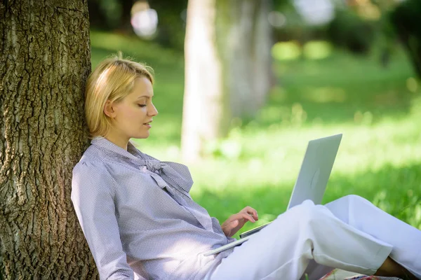 Natural environment office. Work outdoors benefits. Education technology and internet concept. Woman with laptop computer work outdoors lean on tree trunk. Girl work with laptop in park sit on grass