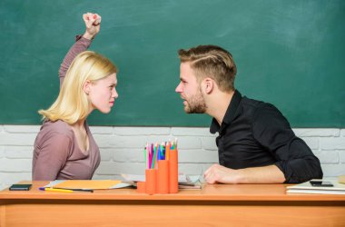 Conflict situation. Teacher and schoolmaster are at quarrel. Angry woman going to man with her fists. Couple arguing in classroom. University or college students back to school. High school education clipart
