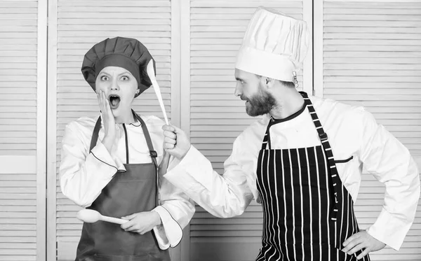 Couple compete in culinary arts. Kitchen rules. Culinary battle concept. Woman and bearded man culinary show competitors. Who cook better. Ultimate cooking challenge. Culinary battle of two chefs