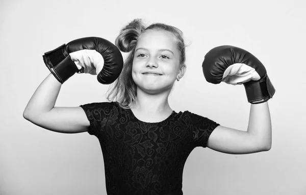 Niña ganadora feliz con guantes de boxeo posando sobre fondo gris. Se siente como ganadora. Crianza para el liderazgo y el ganador. Movimiento feminista. Fuerte niño orgulloso ganador concurso de boxeo —  Fotos de Stock