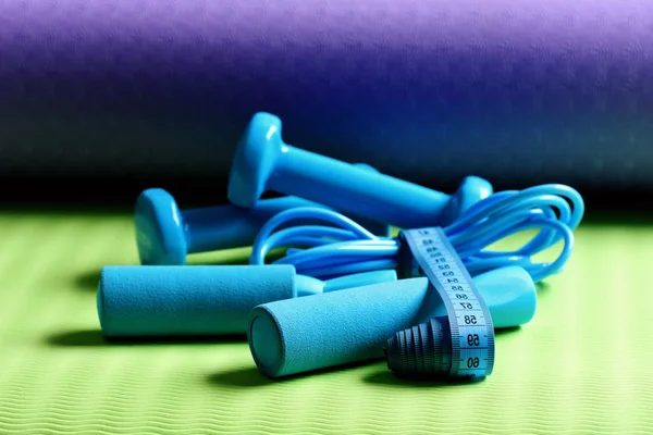 Tape around jump rope and barbells on yoga mat