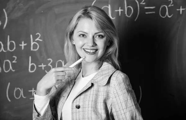 Kondisi kerja yang harus dipertimbangkan calon guru. Wanita tersenyum latar belakang papan tulis kelas pendidik. Kondisi kerja guru. Dia menyukai pekerjaannya. Kembali ke konsep sekolah — Stok Foto
