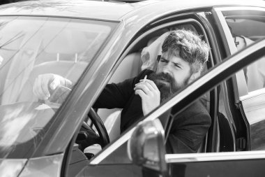 Sürücü duman sigara. Dakika dinlenmek için. İşadamı araç sigara zor görüşmelerin ardından yorgun. Yasaktır, araçlar için özel olarak yasaklıyor. Adam sakallı işadamı süre arabada oturup Sigara İçilmeyen