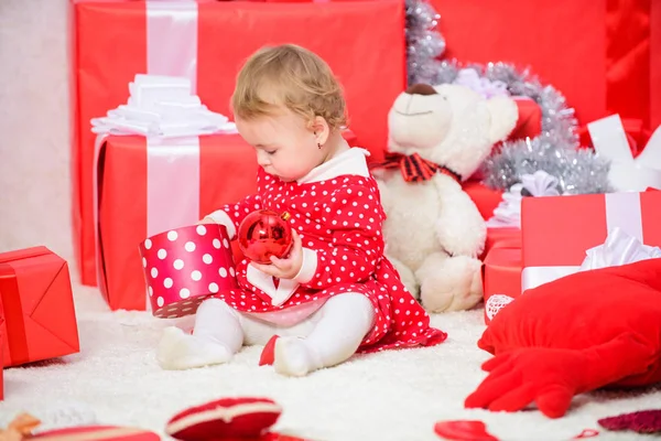 Вещи, связанные с малышами на Рождество. Маленькая девочка играет рядом с кучей подарочных коробок. Семейный праздник. Подарки для первого ребенка. Рождественские мероприятия для малышей. Рождественские подарки для малыша — стоковое фото