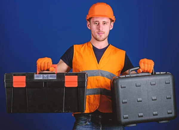 Muž v helmu, přilbu drží nástrojů a kufr s nástroje, modré pozadí. Pracovníka, opraváři, opravář, tvůrce na zamyšlenou tváři výběru vybavení pro práci. Koncepce nástrojů a zařízení — Stock fotografie