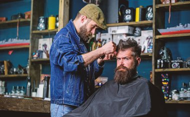 Hipster istemci Başlarken saç kesimi. Kuaför saç kesme makinesi ile saç modeli sakallı adam berber arka plan için çalışır. Hipster yaşam tarzı kavramı. İstemci Tapınağı clipper kırpma kıllı Kuaför