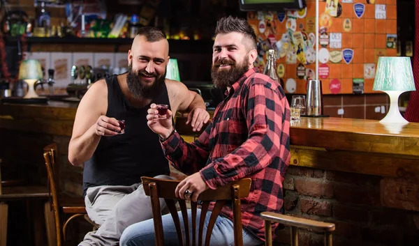 Bebidas alcohólicas fuertes. Viernes relajarse en el pub. Amigos relajándose en el pub. Concepto de salud. Hipster brutal barbudo bebiendo alcohol con un amigo en el mostrador del bar. Hombres borrachos relajándose en el pub divirtiéndose —  Fotos de Stock