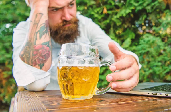 Fan watch stream online while sit terrace outdoors drink beer. Brutal man leisure with beer and sport game. Football fan bearded hipster watch game on laptop screen. Disappointed with game result