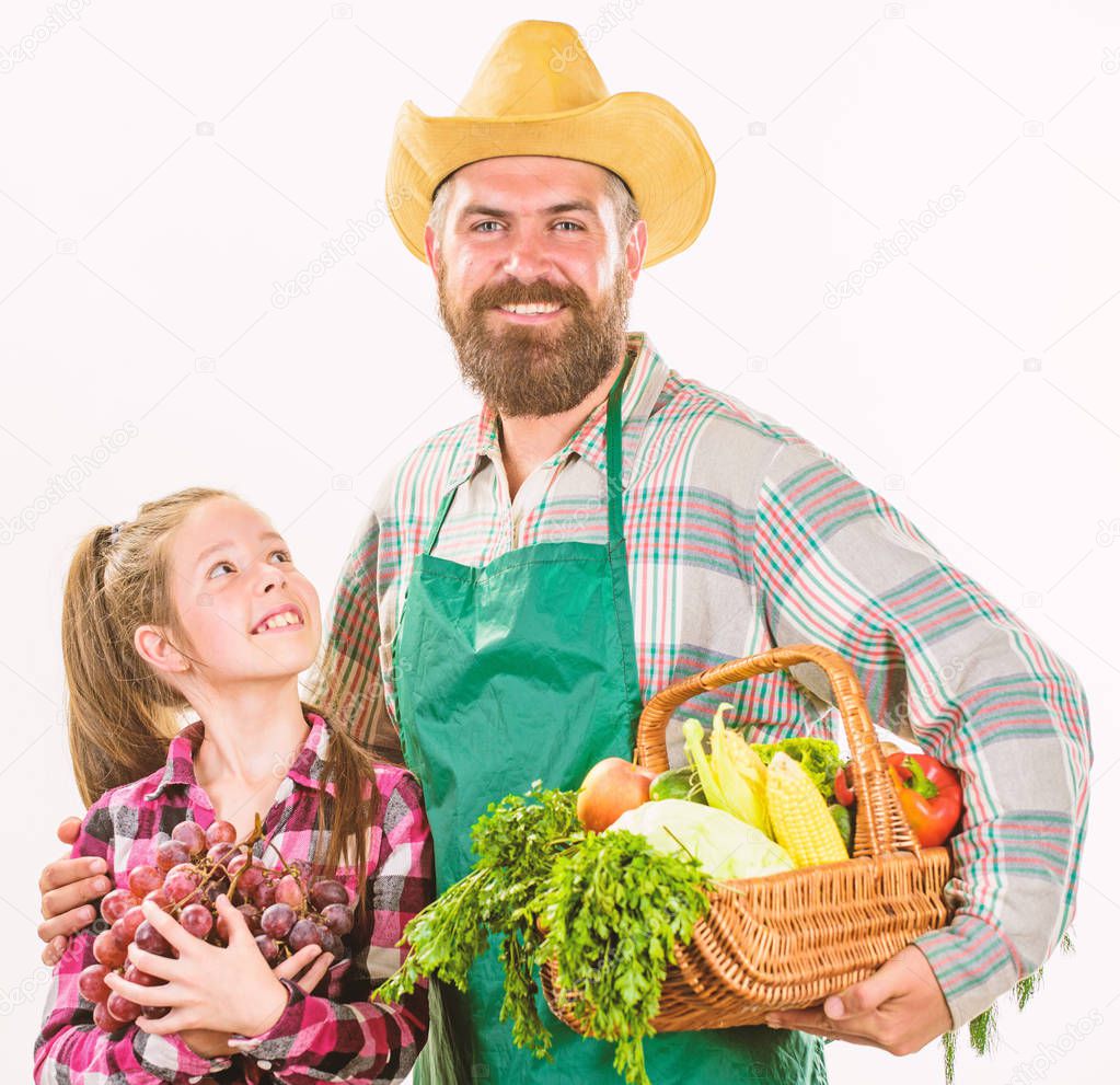 Man bearded rustic farmer with kid. Farmers family homegrown harvest. Father farmer or gardener with daughter hold basket harvest vegetables. Gardening and harvesting. Family farm organic vegetables