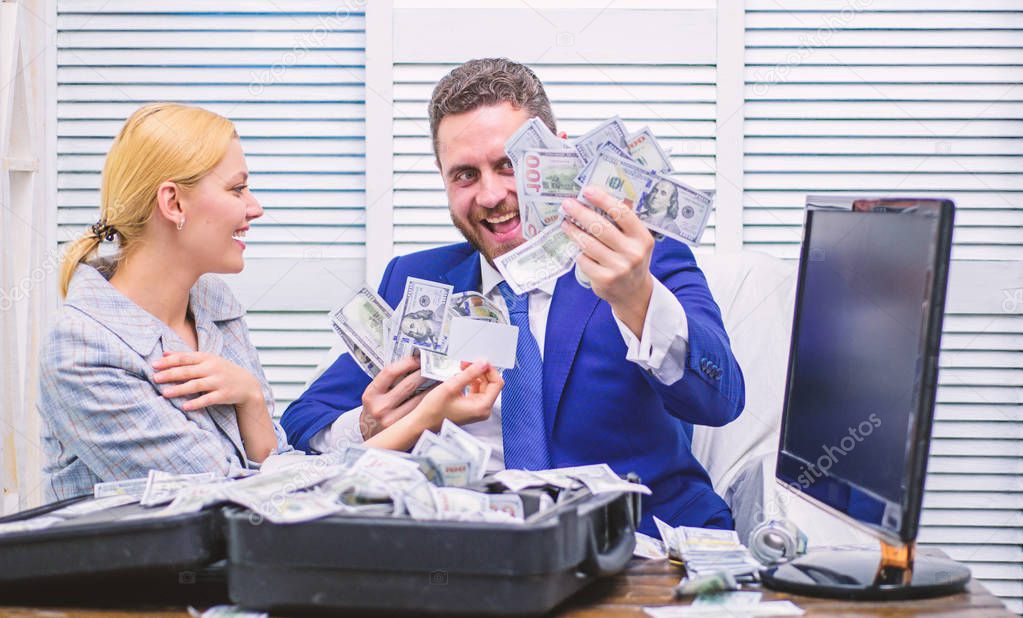 Excited successful businessman opened a box with money and rejoices in profits. Business, people, success and fortune concept. Businessman formal suit hold cash dollars hands.
