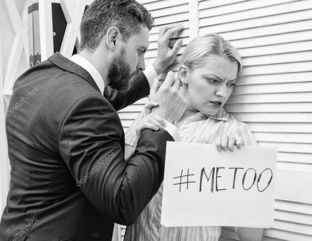 Prejudice office. Manager putting his hand on the shoulder of his secretary, at the office. Movement against sexual harassment. Woman showing a note with the text me too.