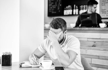 Dostum hayal kırıklığına çaresiz yüz kafe bir fincan kahve ve Not defteri ile otur. Baş ağrısı ve stres. Yaratıcılık ve ilham krizde. Adam baş ağrısı muzdarip. Son Tarih önümüzdeki arama fikirler gerek ilham