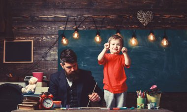 Baba Çocuk oynarken boyama. Küçük çocuk yumruklarını meşgul babasının yanında duran gösterilen. Konsantre baba ve oynak çocuk