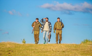 Avcılar silahlı güneşli sonbahar gün yürür, yürür. Acımasız hobi. Çocuklar için avcılık toplandı. Grup erkek avcılar veya gamekeepers doğa arka plan mavi gökyüzü. Erkek av tüfekleri taşırlar. Hobi ve eğlence avcılık