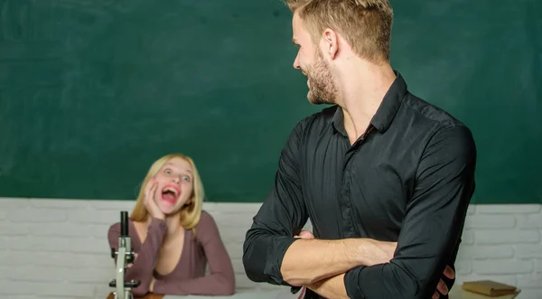 Inteligente e altamente treinado. Bonito homem de pé mãos cruzadas na sala de aula com o professor. Estudante do liceu a dar aulas. Estudante do sexo masculino com examinador no exame. Estudante universitário ou universitário — Fotografia de Stock